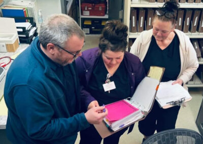 A few staff members looking over notes in a binder at Golden Good Shepherd Home